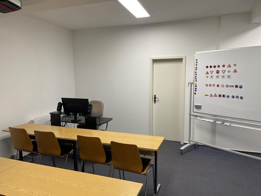 Heller Theorieraum der Indrive Fahrschule in Rottweil mit Verkehrszeichen-Tafel und Whiteboard
